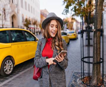 good-looking-business-woman-texting-message-while-walking-street (1)